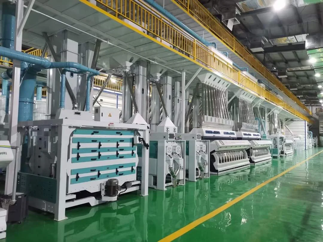 Rice mill machinery in a factory hall with yellow safety railings
